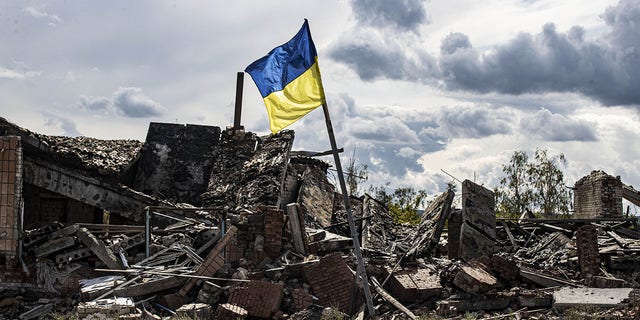 A Ukrainian flag waves in a residential area heavily damaged in the village of Dolyna in Donetsk Oblast, Ukraine, after the withdrawal of Russian troops on September 24. 
