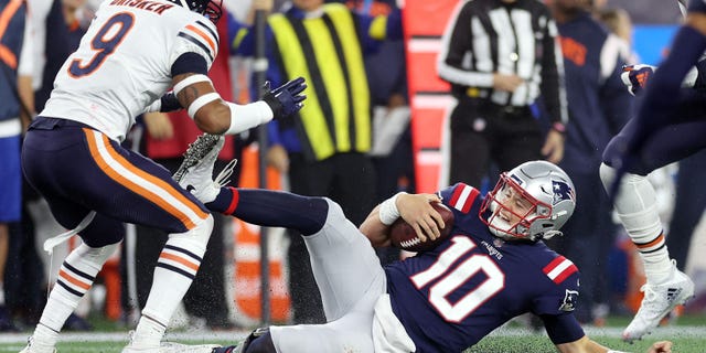 #10 Mac Jones of the New England Patriots slides after a first-half run with the ball against the Chicago Bears at Gillette Stadium on October 24, 2022 in Foxborough, Massachusetts.