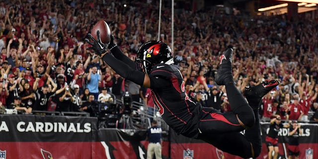 Marco Wilson #20 of the Arizona Cardinals dives into the end zone for a touchdown after intercepting a pass during the game against the New Orleans Saints at State Farm Stadium on October 20, 2022 in Glendale, Arizona.