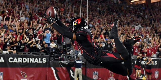 Marco Wilson #20 of the Arizona Cardinals dives into the end zone for a touchdown after intercepting a pass during a game against the New Orleans Saints at State Farm Stadium in Glendale, Arizona on October 20, 2022.