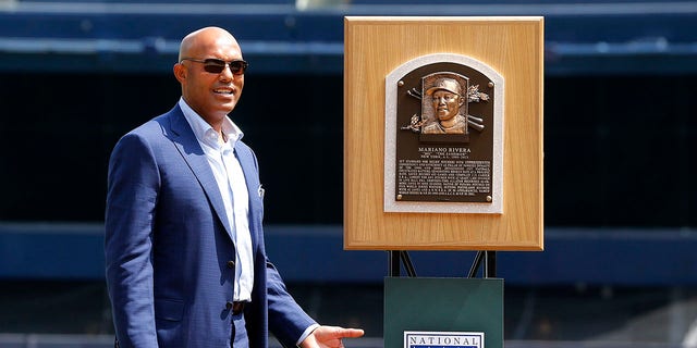 Mariano Rivera, a 2019 National Baseball Hall of Fame inductee and former New York Yankee acknowledges the crowd as he stands next to his Hall of Fame plaque during a ceremony in his honor before a game between the Yankees and the Cleveland Indians at Yankee Stadium Aug. 17, 2019, in New York City. 