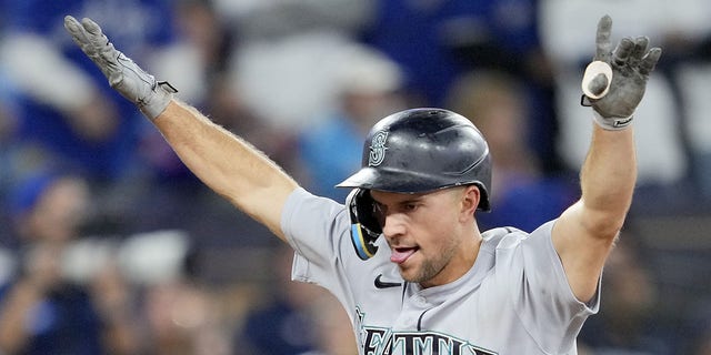 Mitch Haniger of the Seattle Mariners celebrates after scoring against the Toronto Blue Jays during the eighth inning in Game 2 of the American League wild-card series at Rogers Centre on Oct. 8, 2022, in Toronto.