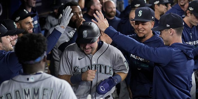 Cal Raleigh of the Seattle Mariners is congratulated by teammates after scoring the go-ahead run against the Toronto Blue Jays during the ninth inning in Game 2 of the American League wild-card series at Rogers Centre on Oct. 8, 2022, in Toronto.
