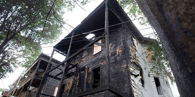 The fire-damaged rear of a three-decker at 25 Peverell St., in Boston's Dorchester neighborhood, appears blackened by flames on Oct. 2, 2022. Entertainers Mark and Donnie Wahlberg's family once lived in the building.