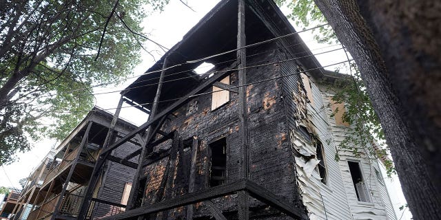 The fire-damaged rear of a three-decker at 25 Peverell St., in Boston's Dorchester neighborhood, appears blackened by flames on Oct. 2, 2022. Entertainers Mark and Donnie Wahlberg's family once lived in the building.