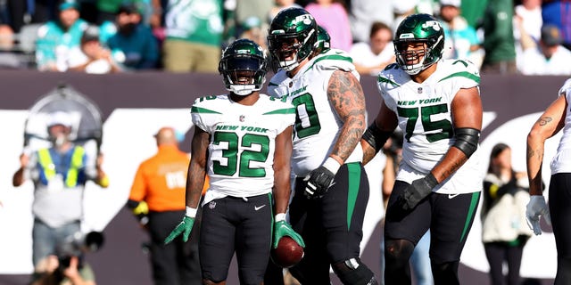 Michael Carter #32 of the New York Jets celebrates a touchdown with teammates against the Miami Dolphins during the fourth quarter at MetLife Stadium on October 09, 2022 in East Rutherford.