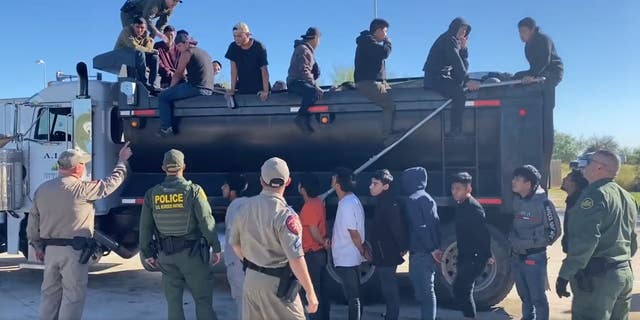 Migrants climb out of a dump truck. (Texas DPS)
