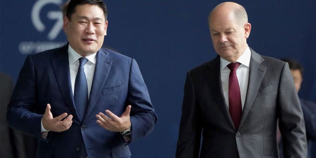 German Chancellor Olaf Scholz (right) and Mongolian Prime Minister Luvsannamsrain Oyun-Erdene (left) speak on their way to a joint press conference in Berlin, Germany, on Oct. 14, 2022.