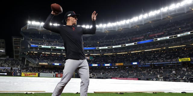 Myles Straw #7 of the Cleveland Guardians tosses a football to fans in the stands prior to playing the New York Yankees in game five of the American League Division Series at Yankee Stadium on October 17, 2022 in New York, New York.