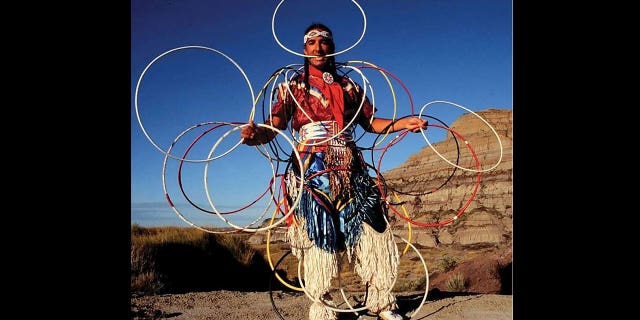 Kevin Locke, an acclaimed Native American flute player, hoop dancer, cultural ambassador and educator, died in South Dakota at age 68 on Sept. 30, 2022, according to his family. Pictured: Kevin Locke performs a hoop dance in the Badlands, South Dakota, in 2002.