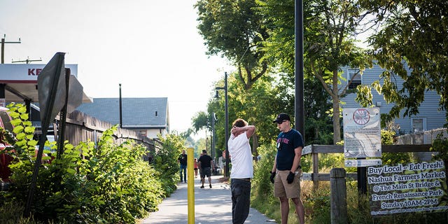 A plainclothes police officer talks to a man along a bike path in Nashua, New Hampshire.