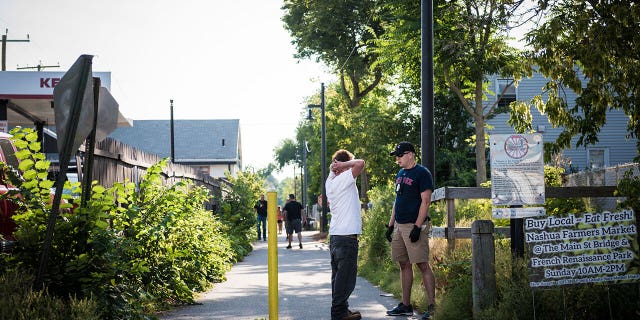 A plainclothes police officer talks to a man along a bike path in Nashua, New Hampshire.