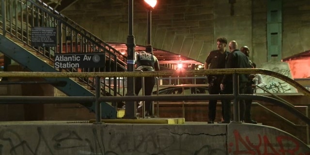 NYPD officers investigating the scene of a fatal subway slashing on Friday. 