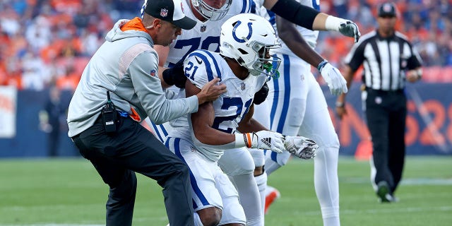 Nyheim Hines of the Indianapolis Colts is helped to his feet after being hit during a game against the Denver Broncos at Empower Field at Mile High in Denver, Colorado, on Thursday.