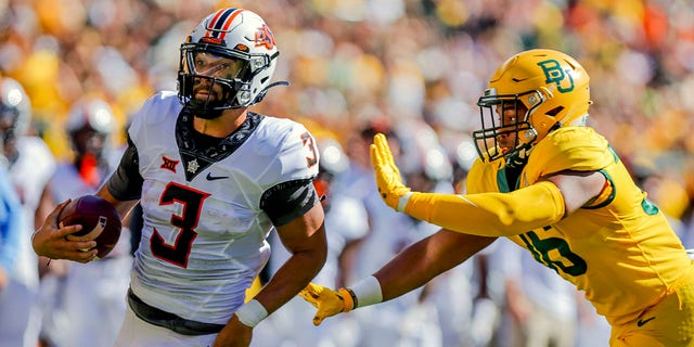 Oklahoma State quarterback Spencer Sanders (3) rushes past Baylor linebacker Tyrone Brown (36) during the first half of a game in Waco, Texas, Saturday, Oct. 1, 2022.