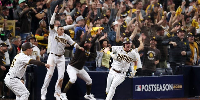 Jake Cronenworth #9 of the San Diego Padres celebrates after hitting a two-run RBI single during the seventh inning against the Los Angeles Dodgers in game four of the National League Division Series at PETCO Park on October 15, 2022 in San Diego, California.