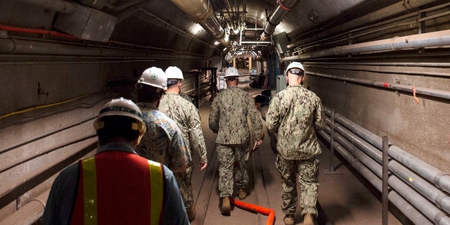 In this file photo provided by the U.S. Navy, Rear Adm. John Korka, Commander, Naval Facilities Engineering Systems Command (NAVFAC), and Chief of Civil Engineers, leads Navy and civilian water quality recovery experts through the tunnels of the Red Hill Bulk Fuel Storage Facility, near Pearl Harbor, Hawaii, on Dec. 23, 2021.