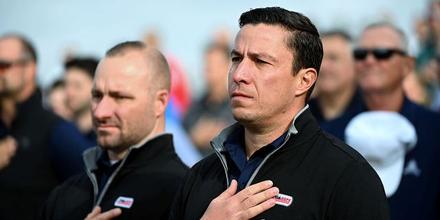Former Army Captain Chris Cordova, center right, and other veterans stand at attention as the National Anthem is sung during the PGA Hope event at Congressional Country Club October 17, 2022 in Bethesda, MD. PGA Hope has specialized golf programs for veterans dealing with PTSD, brain injuries or other issues.