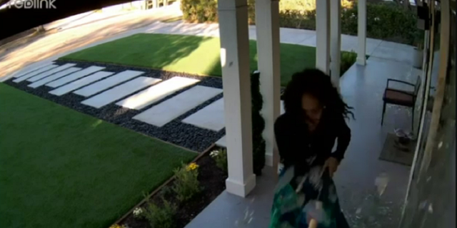 Shards of glass are seen raining down after the suspect, identified as Beverly Baker, is seen swinging a pickax at the home.