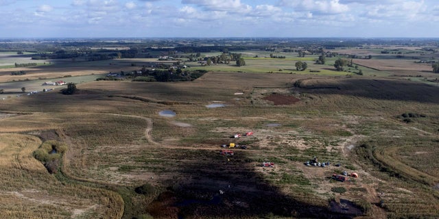 Firefighters work in the field near the Druzhba pipeline where an oil leak was detected, near the village of Zurawice, Poland, October 12, 2022. (REUTERS/Kacper Pempel)