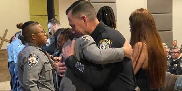 Escondido police Sgt. Valdivia and El Paso County Deputy Young hug during Young's graduation ceremony.