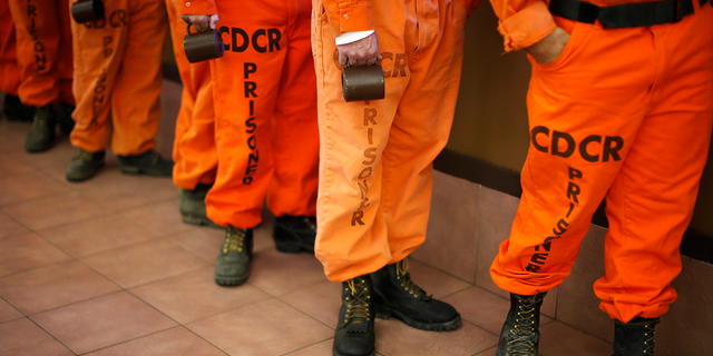 Prison inmates wearing firefighting boots line up for breakfast at Oak Glen Conservation Fire Camp #35 in Yucaipa, California