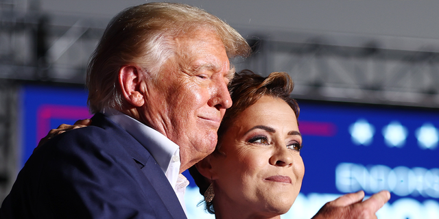 Former President Donald Trump (L) embraces Arizona's Republican nominee for Governor Kari Lake, whom he endorsed, during a campaign rally in Arizona.