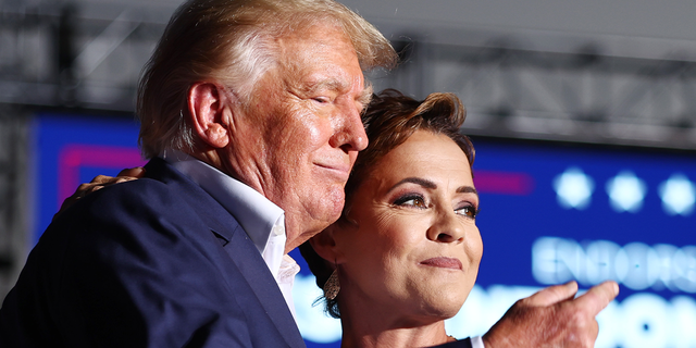 Former President Trump, left, embraces Arizona Republican nominee for governor Kari Lake, who he has endorsed, during a campaign rally at Legacy Sports USA on Oct. 9, 2022 in Mesa, Arizona.