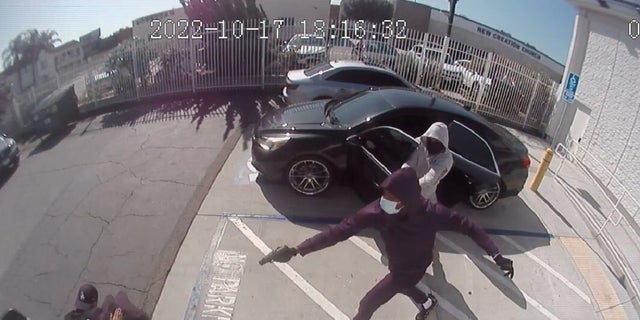 Security video captures two armed robbers shooting a Loomis guard during an armored car heist this week. The pair were arrested Friday and face federal charges. 
