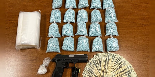 Police searched the car and discovered 20,000 fentanyl pills, a half-ounce of cocaine, a loaded gun and over $1,200 in cash.