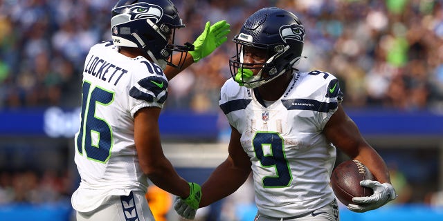 Seattle Seahawks' Tyler Lockett #16 celebrates with Kenneth Walker III #9 after a touchdown during the first quarter of the game against the Los Angeles Chargers at SoFi Stadium on October 23, 2022 in Inglewood, California.