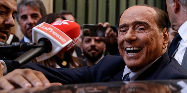 Silvio Berlusconi is mobbed by press as he leaves a reunion to decide the group leaders of at the Lower Chamber, in Rome, Tuesday, Oct.18, 2022. 