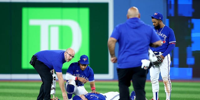 George Springer of the Toronto Blue Jays lies on the field after colliding with teammate Bo Bichette during the eighth inning against the Seattle Mariners in Game 2 of the American League wild-card series at Rogers Centre on Oct. 8, 2022, in Toronto.
