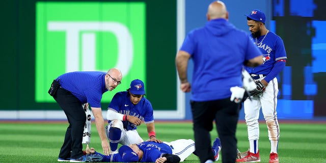 George Springer of the Toronto Blue Jays lies on the field after colliding with teammate Bo Bichette during the eighth inning against the Seattle Mariners in Game 2 of the American League wild-card series at Rogers Centre on Oct. 8, 2022, in Toronto.