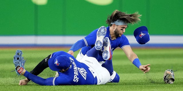 George Springer (4) of the Toronto Blue Jays collides with teammate Bo Bichette during the eighth inning against the Seattle Mariners in Game 2 of the American League wild-card series at Rogers Centre on Oct. 8, 2022, in Toronto.