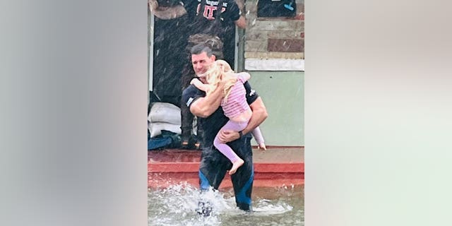 St. Augustine firefighter Hardus Oberholzer rescues a little girl from her Florida home during Hurricane Ian. Oberholzer was one of several first responders engaging in the department's 26 rescue missions in St. Augustine this past week.