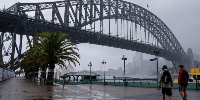 Commuters walk to a ferry during rainy weather in Sydney, Australia, on Oct. 6, 2022.