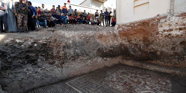 People look at a large mosaic that dates back to Roman era in the town of Rastan, Syria, Wednesday, Oct. 12, 2022. Syrian officials said it is the most important archaeological discovery since the conflict began 11 years ago. 