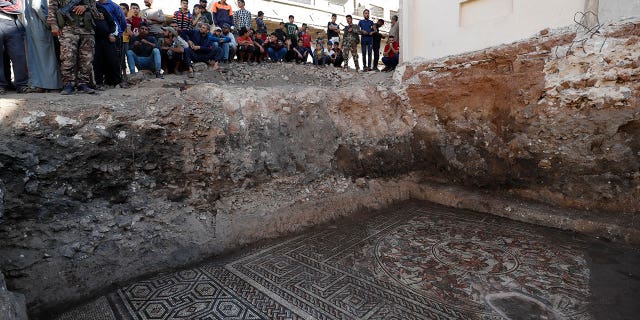 People look at a large mosaic that dates back to Roman era in the town of Rastan, Syria, Wednesday, Oct. 12, 2022. Syrian officials said it is the most important archaeological discovery since the conflict began 11 years ago.