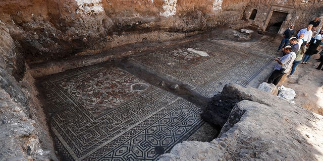 People look at a large mosaic that dates back to Roman era in the town of Rastan, Syria, Wednesday, Oct. 12, 2022. Syrian officials said it is the most important archaeological discovery since the conflict began 11 years ago. 