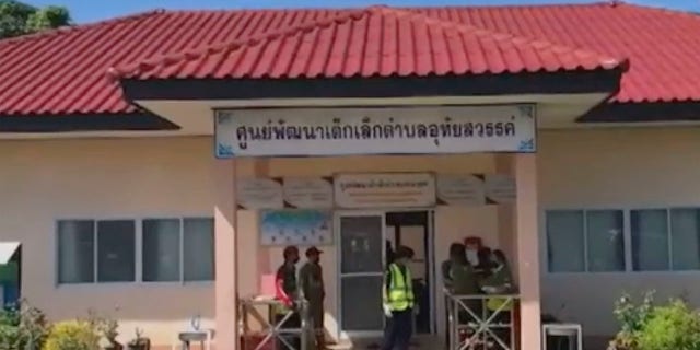 In this image taken from video, officials enter the site of an attack at a day care canter, Thursday, Oct. 6, 2022, northeastern Thailand. More than 30 people, primarily children, were killed Thursday when a gunman opened fire the child care center authorities said.