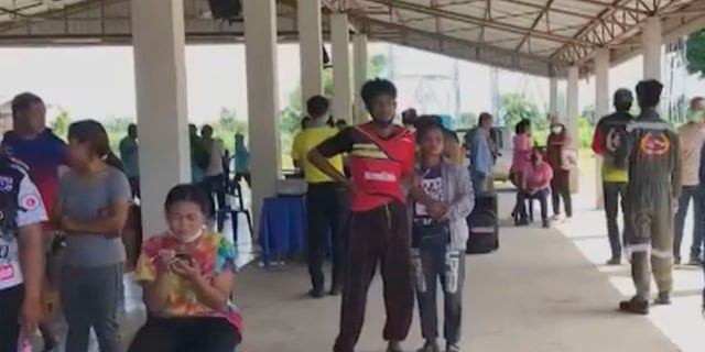 In this image taken from video, people gather outside the site of an attack at a day care canter, Thursday, Oct. 6, 2022, in northeastern Thailand. More than 30 people, primarily children, were killed Thursday when a gunman opened fire in the child care center authorities said.