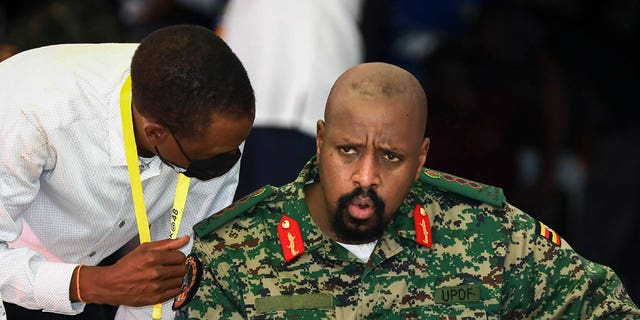 Son of Uganda's President Yoweri Museveni, Lt. Gen. Muhoozi Kainerugaba, right, speaks to Attorney General Kiryowa Kiwanuka, left, at a "Thanksgiving" ceremony in Entebbe, Uganda, on May 7, 2022.