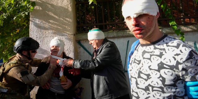Οι άνθρωποι λαμβάνουν ιατρική περίθαλψη στον τόπο του ρωσικού βομβαρδισμού στο Κίεβο της Ουκρανίας, Δευτέρα 10 Οκτωβρίου 2022 (AP Photo/Efrem Lukatsky)