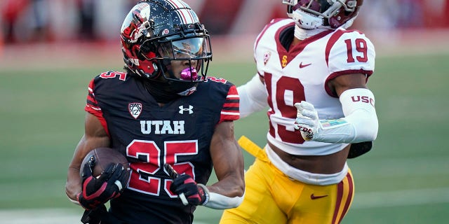 Le receveur large de l'Utah Jaylen Dixon (25 ans) porte le ballon devant le demi défensif du sud de la Californie Jaylin Smith (19 ans) pendant la première moitié d'un match de football universitaire de la NCAA le samedi 15 octobre 2022 à Salt Lake City.