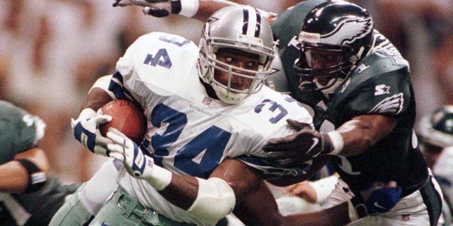 Dallas Cowboys Herschel Walker (34) is taken down by Philadelphia Eagles Derrick Whiterspoon as he returns a kick during the first half of their game September 15, 1997. The Cowboys defeated the Eagles 21-20.