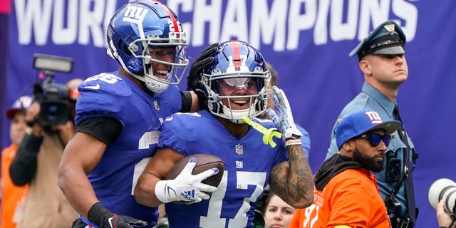 New York Giants' Wan'Dale Robinson (17) celebrates with teammate Saquon Barkley (26) after scoring a touchdown during the first half of an NFL football game against the Baltimore Ravens, Sunday, Oct. 16, 2022, in East Rutherford, N.J.
