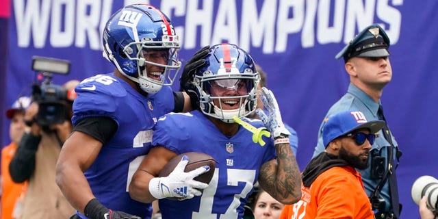 New York Giants' Wan'Dale Robinson (17) celebrates with teammate Saquon Barkley (26) after scoring a touchdown during the first half of an NFL football game against the Baltimore Ravens, Sunday, Oct. 16, 2022, in East Rutherford, N.J.