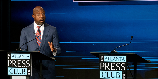 Sen. Raphael Warnock, D-Ga., speaks next to an empty podium set up for Republican challenger Herschel Walker, who was invited but did not attend, during a U.S. Senate debate as part of the Atlanta Press Club Loudermilk-Young Debate Series in Atlanta on Sunday, Oct. 16, 2022.