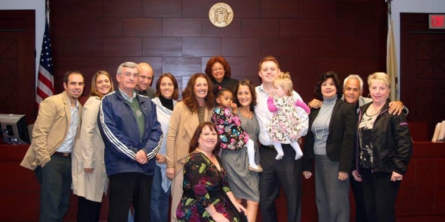 Danielle Gletow of New Jersey (in dress, center, holding Mia) on the day her eldest daughter's adoption was finalized.